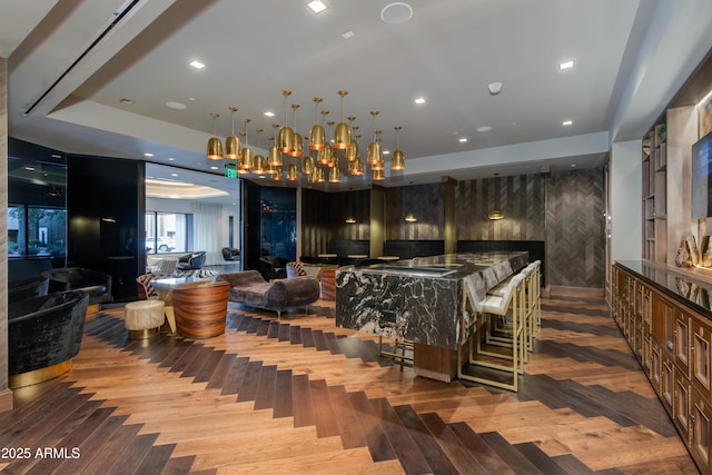 bar with a tray ceiling and hardwood / wood-style flooring