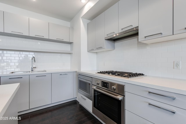 kitchen with white cabinetry, stainless steel appliances, dark hardwood / wood-style flooring, and sink