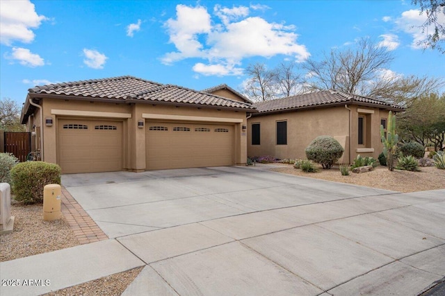 view of front facade featuring fence, driveway, stucco siding, a garage, and a tile roof