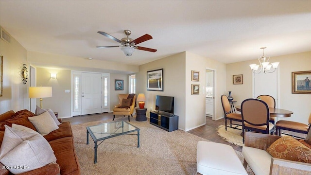 living room featuring hardwood / wood-style flooring and ceiling fan with notable chandelier