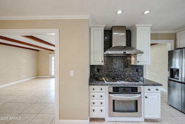 kitchen with light tile patterned floors, wall chimney range hood, appliances with stainless steel finishes, and white cabinets