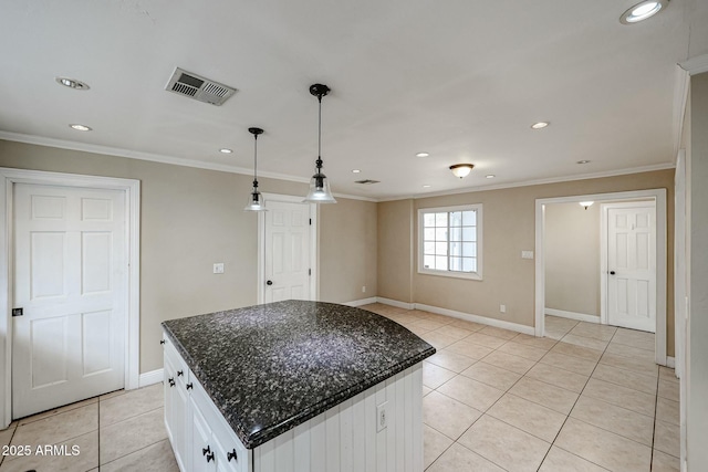 kitchen featuring light tile patterned flooring, visible vents, white cabinets, a center island, and decorative light fixtures