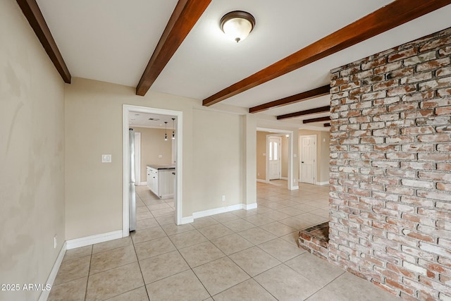 unfurnished room featuring beamed ceiling, baseboards, and light tile patterned floors