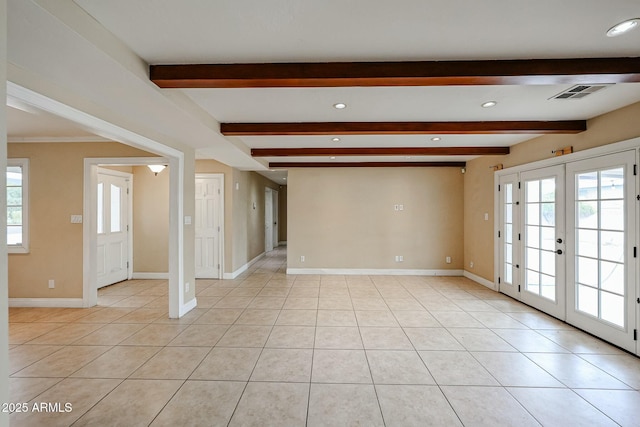 unfurnished room featuring a wealth of natural light, visible vents, and light tile patterned floors