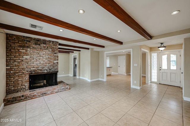 unfurnished living room with light tile patterned floors, a fireplace, visible vents, and baseboards