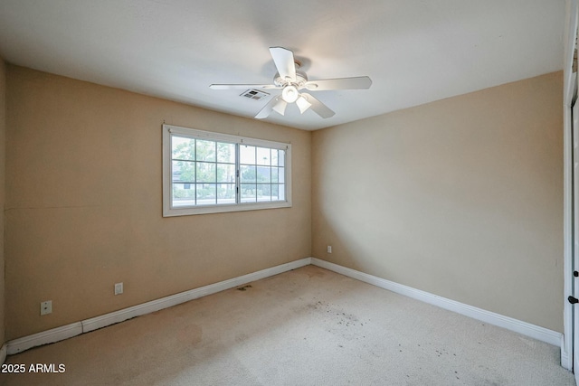 empty room featuring baseboards, visible vents, and ceiling fan