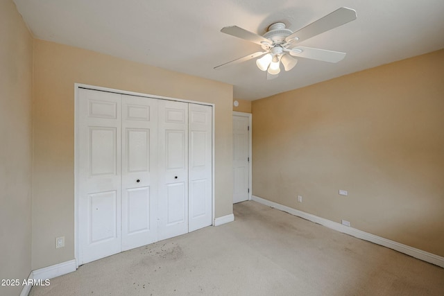 unfurnished bedroom featuring a closet, light carpet, ceiling fan, and baseboards