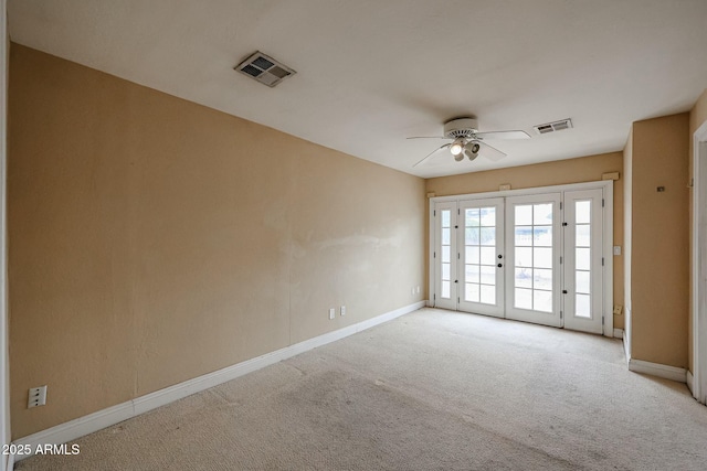 unfurnished room with baseboards, visible vents, french doors, and light colored carpet