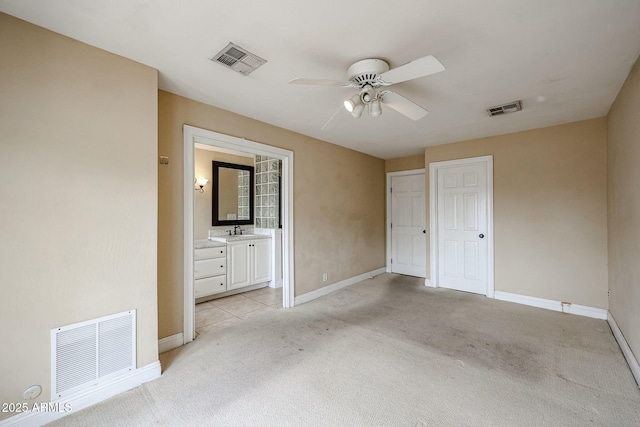 unfurnished bedroom with visible vents, a sink, and light colored carpet