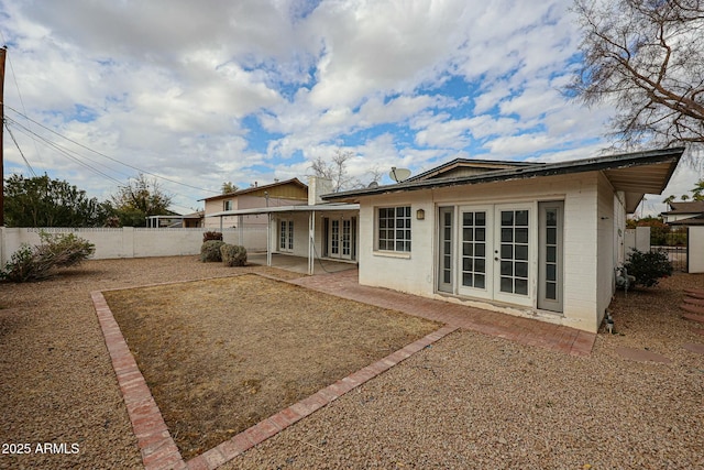 rear view of property featuring a patio area, french doors, and a fenced backyard