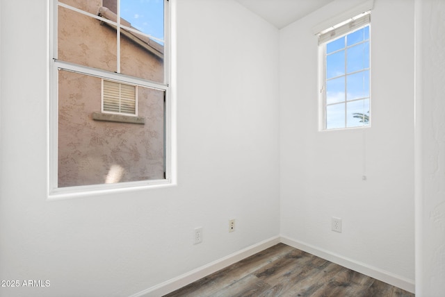 empty room featuring dark wood-style floors and baseboards