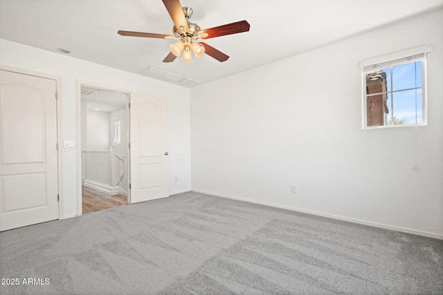 unfurnished bedroom with carpet flooring, a ceiling fan, and baseboards