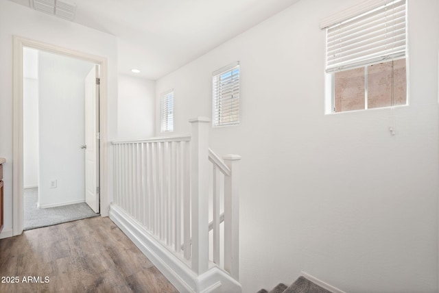 hallway featuring visible vents and wood finished floors