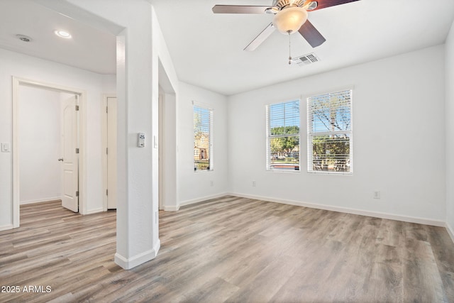 unfurnished bedroom featuring ceiling fan, light wood-style floors, visible vents, and baseboards