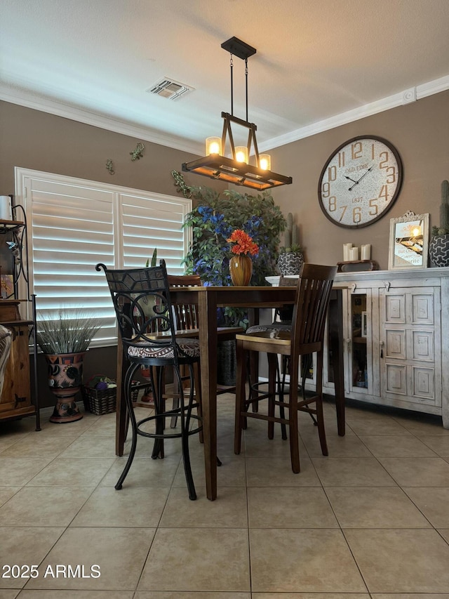 tiled dining room featuring ornamental molding, a chandelier, and visible vents