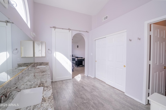 bathroom featuring double vanity, visible vents, wood finished floors, and a sink