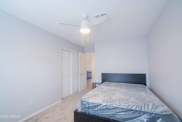 carpeted bedroom with a closet, visible vents, ceiling fan, and baseboards