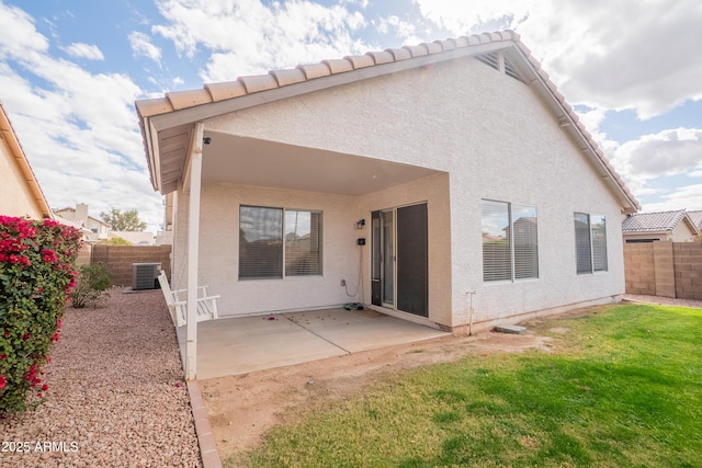 back of house with stucco siding, cooling unit, a yard, a fenced backyard, and a patio