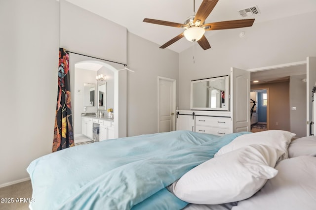 bedroom with light colored carpet, arched walkways, high vaulted ceiling, ensuite bathroom, and visible vents