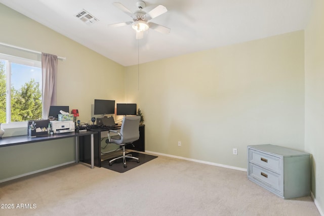 home office with a ceiling fan, light colored carpet, visible vents, vaulted ceiling, and baseboards