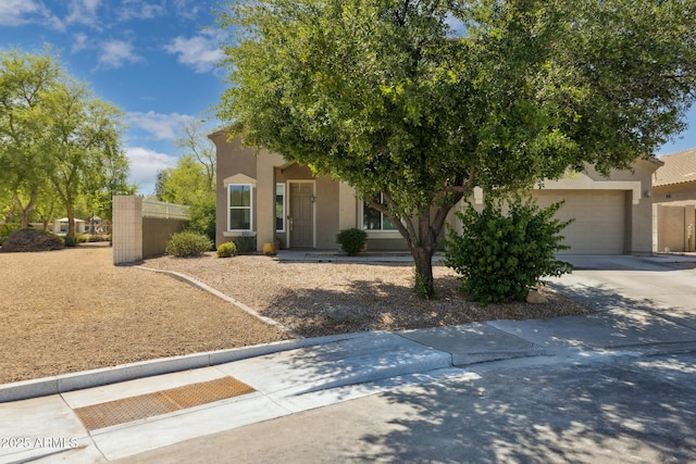view of front facade featuring concrete driveway, a garage, and stucco siding