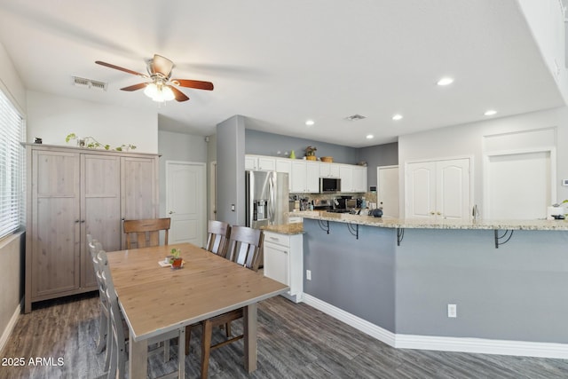dining room with visible vents, dark wood-style flooring, and ceiling fan