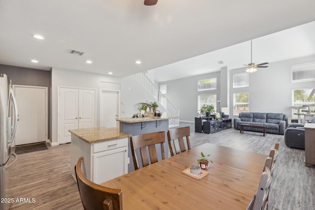 dining room with visible vents, stairs, light wood-style floors, ceiling fan, and recessed lighting