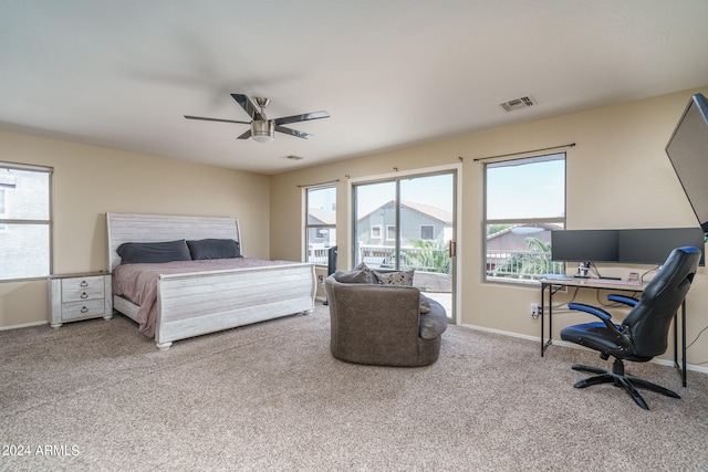 carpeted bedroom with multiple windows, ceiling fan, and access to exterior