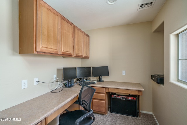 office area with light carpet, plenty of natural light, and built in desk