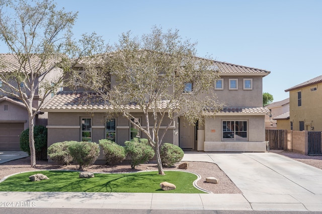 mediterranean / spanish-style home with a front yard and a garage