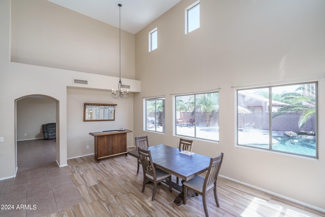 dining area featuring a wealth of natural light, a chandelier, and a high ceiling