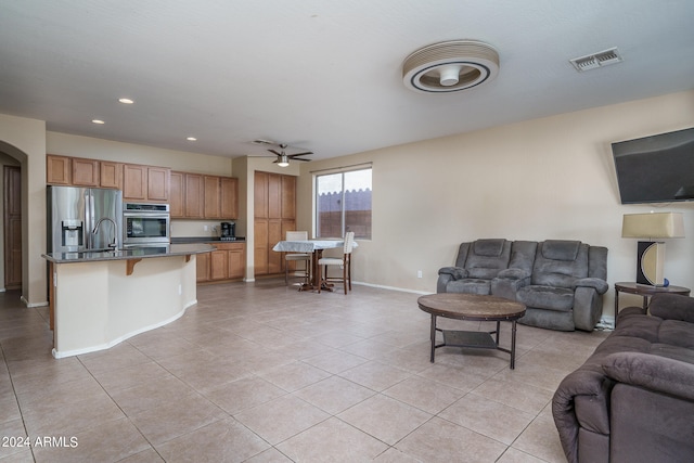 tiled living room featuring sink and ceiling fan