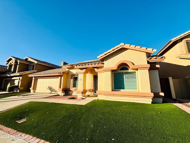 view of front of property with a garage and a front lawn