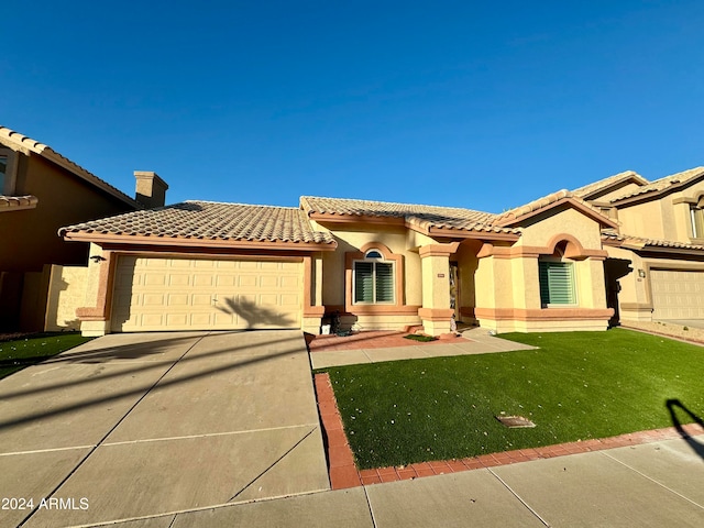 mediterranean / spanish home featuring a front yard and a garage