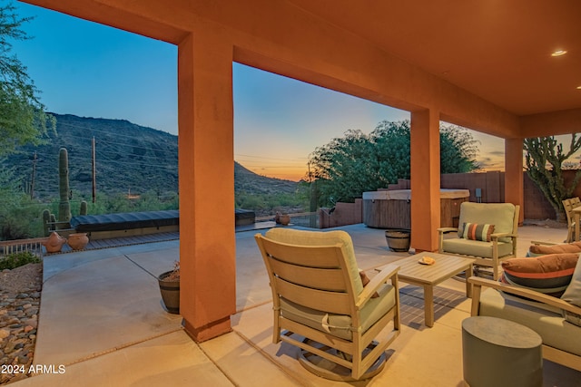 patio terrace at dusk featuring a mountain view and an outdoor hangout area