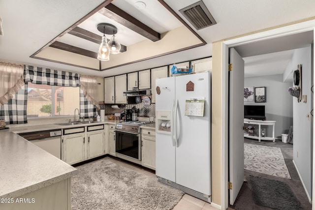 kitchen with visible vents, under cabinet range hood, light countertops, white appliances, and a sink