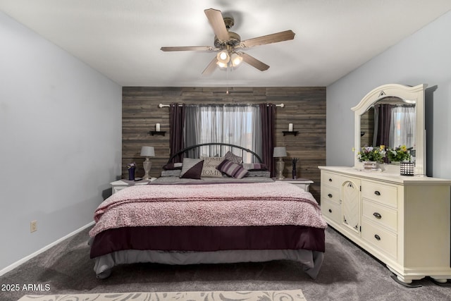 bedroom with dark colored carpet, wooden walls, and an accent wall