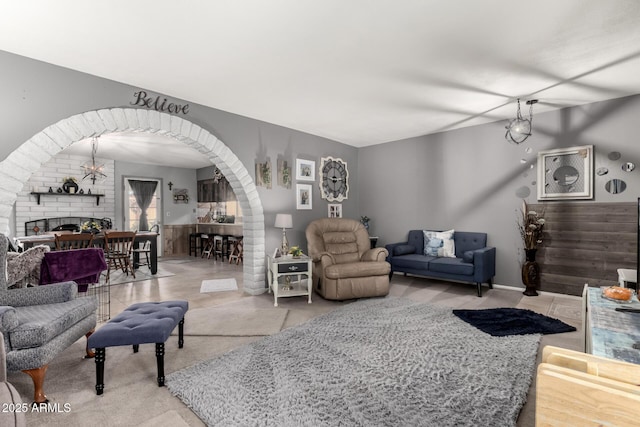 living room featuring arched walkways and a fireplace