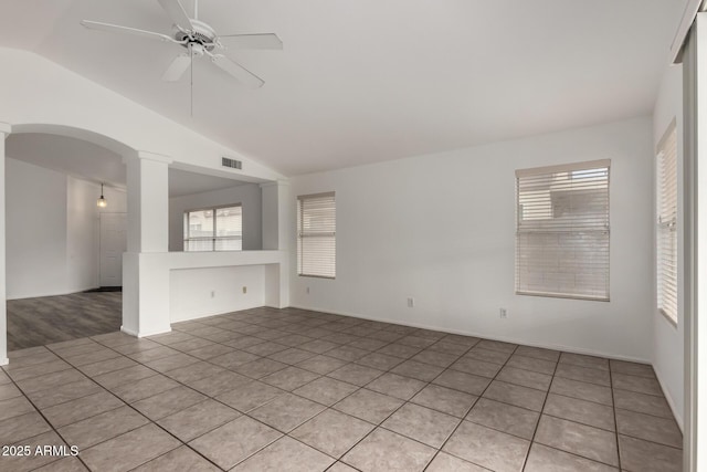 unfurnished room with vaulted ceiling, ceiling fan, light tile patterned floors, and ornate columns