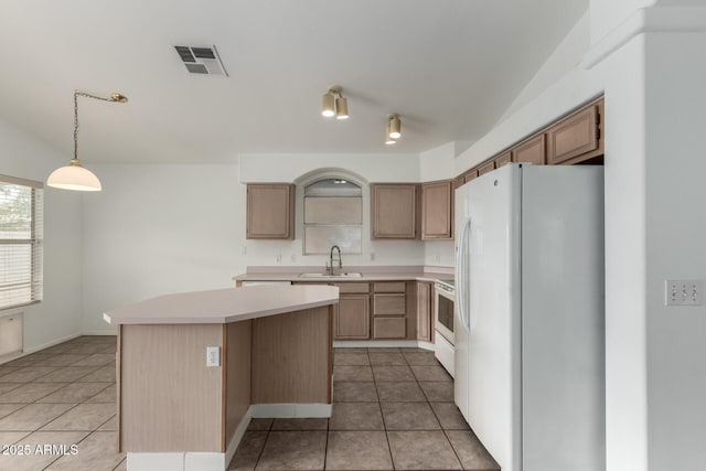 kitchen with white appliances, a center island, tile patterned floors, sink, and hanging light fixtures