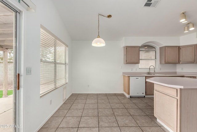 kitchen with pendant lighting, sink, white dishwasher, light tile patterned floors, and light brown cabinetry