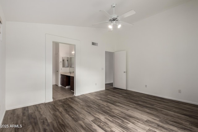 unfurnished bedroom with ceiling fan, connected bathroom, dark hardwood / wood-style floors, and lofted ceiling