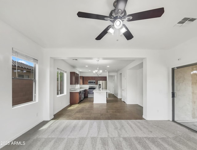 unfurnished living room featuring dark colored carpet, visible vents, recessed lighting, ceiling fan with notable chandelier, and dark tile patterned floors