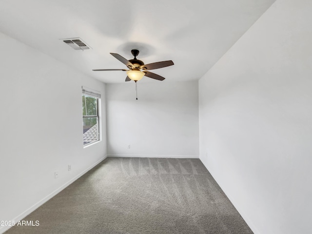 carpeted empty room featuring baseboards, visible vents, and ceiling fan