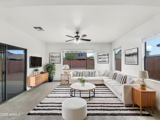 living area with visible vents, carpet floors, ceiling fan, and a healthy amount of sunlight
