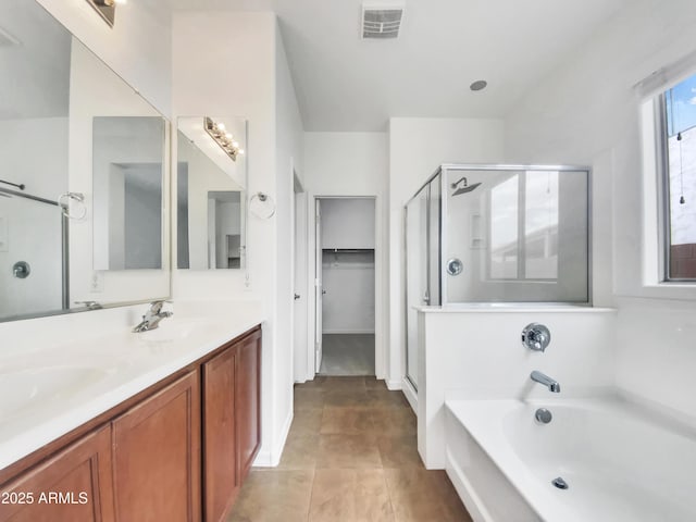 bathroom with a sink, double vanity, visible vents, a shower stall, and a garden tub