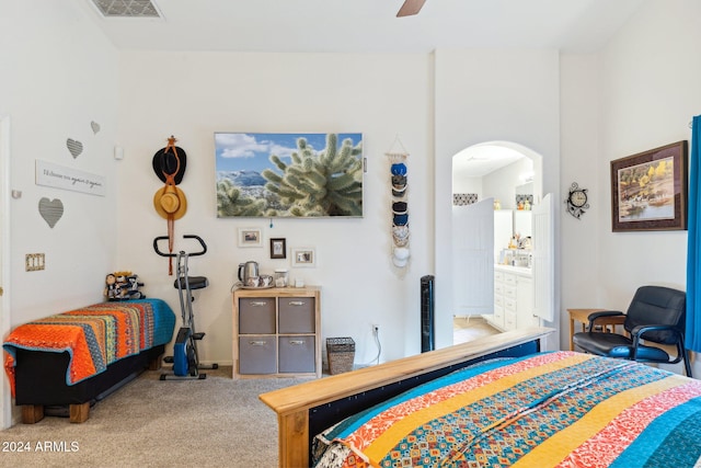 carpeted bedroom featuring ceiling fan and ensuite bath