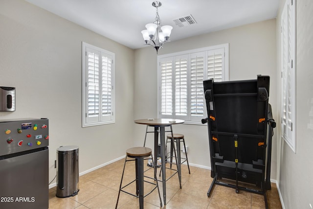 tiled dining space featuring visible vents, plenty of natural light, baseboards, and a chandelier