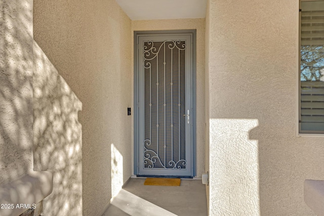 doorway to property featuring stucco siding