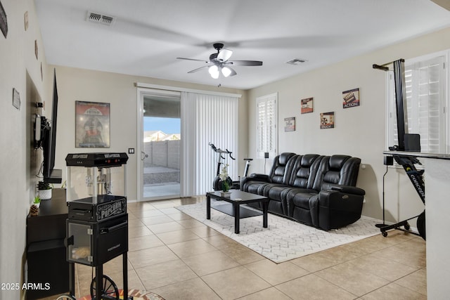 living room featuring light tile patterned floors, a ceiling fan, and visible vents